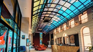 Eine geräumige Lobby mit hoher Decke, großen Fenstern und einer Rezeption.
