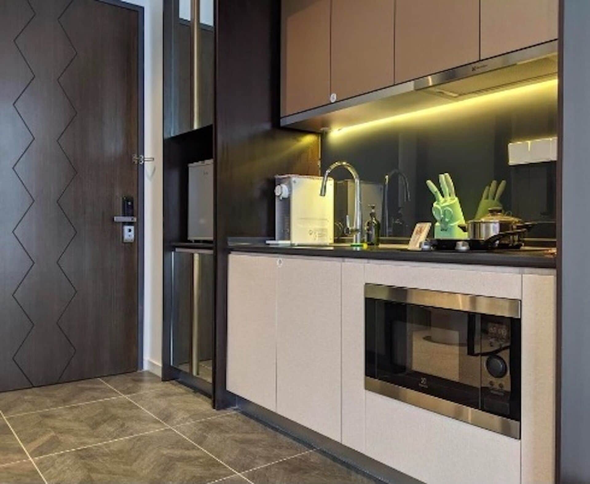 A modern kitchen with a built-in oven, a microwave, and a stainless steel range hood.