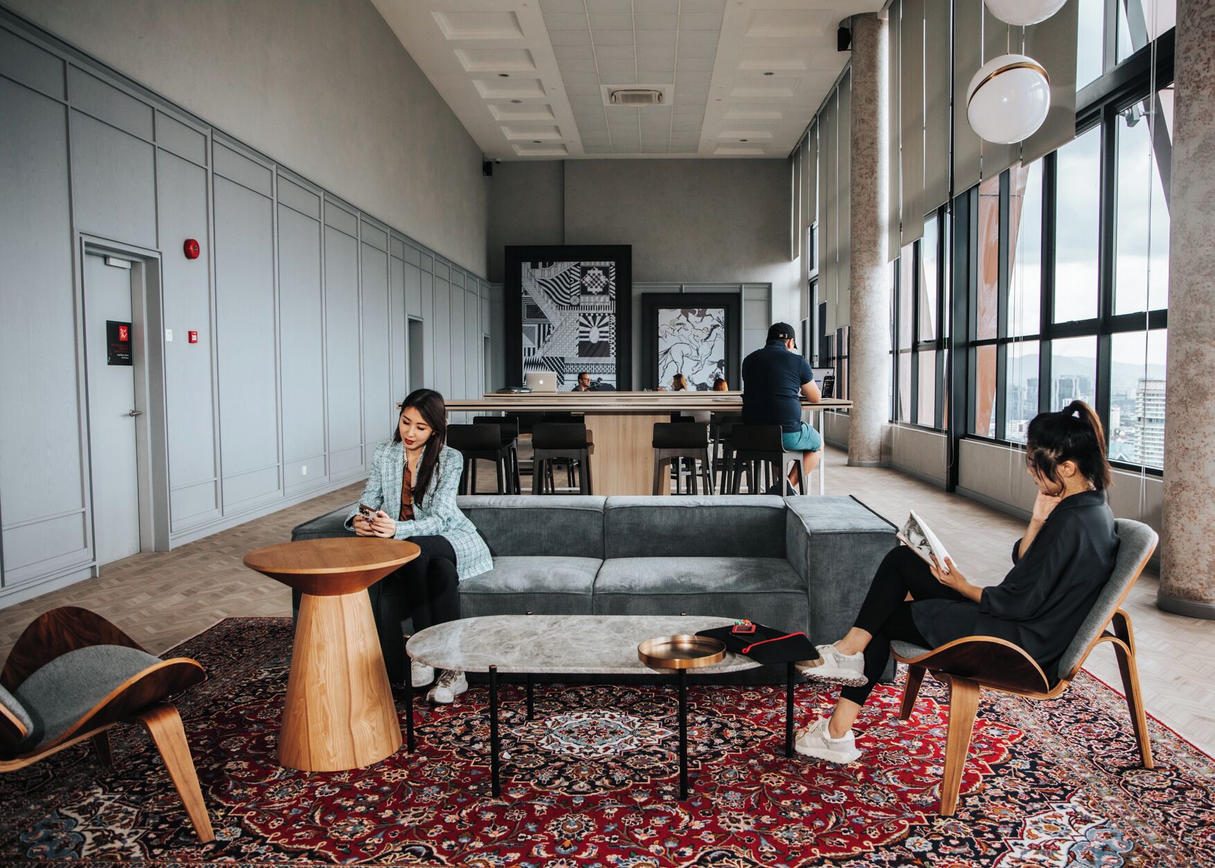 A modern interior with a bar area, seating, and large windows.