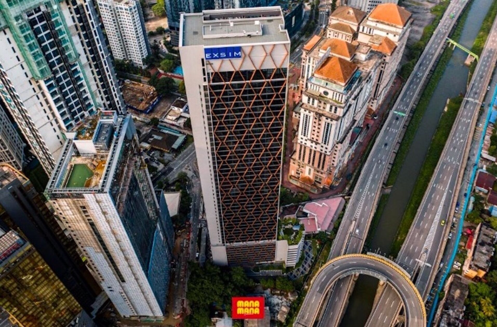 A high-rise building with a grid-like facade and signage for 'EXSIM'.