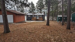 A cabin with a covered deck and a garage. - Moon Lake Waterfront Getaway (Lewiston)