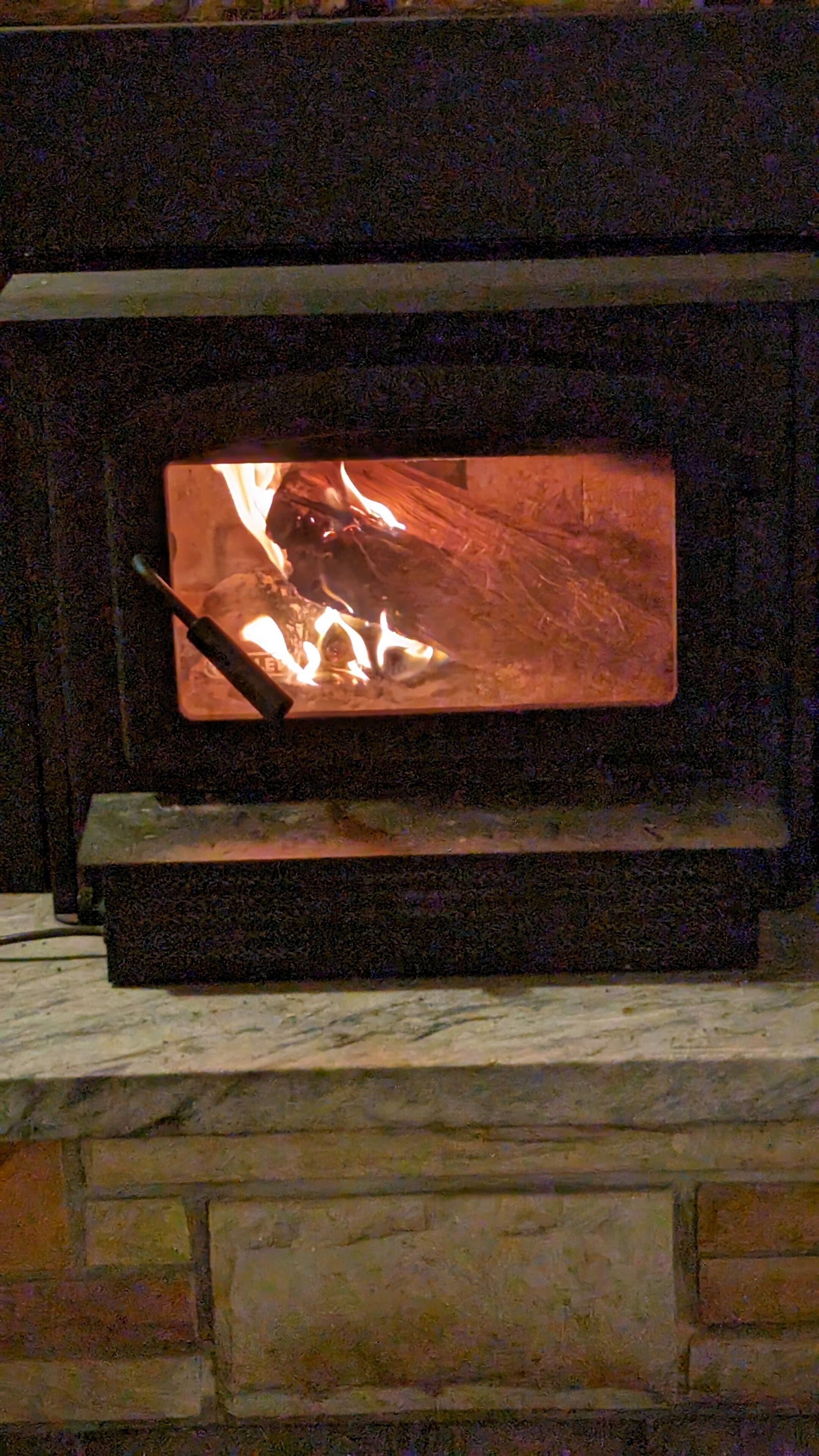 A fireplace with a fire burning inside.