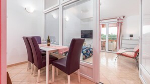 Un comedor con una mesa, sillas y una botella de vino.