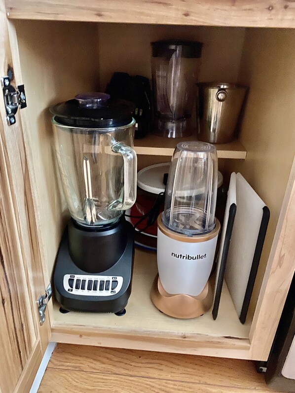 Een keukenkastje met een blender en een keukenmachine.