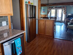 A kitchen with wooden cabinets, a stainless steel refrigerator, and a granite countertop. - Waterfront home for 3! 2 decks, 2 kayaks,hottub, dock, grill, firepit, wifi, a/c (Erie)