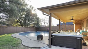 A backyard with a swimming pool, hot tub, and covered patio area. - Cheerful Home w/ Private Hot Tub, Big Fenced Yard, & Pool.  Pet Friendly! (Crowley)