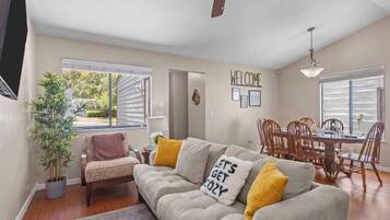 Relax in this open-plan living space with a dining area and large window offering a view of the outdoors.