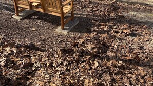 Ein Spielplatz mit Rutsche, Bänken und einem Spielhäuschen.