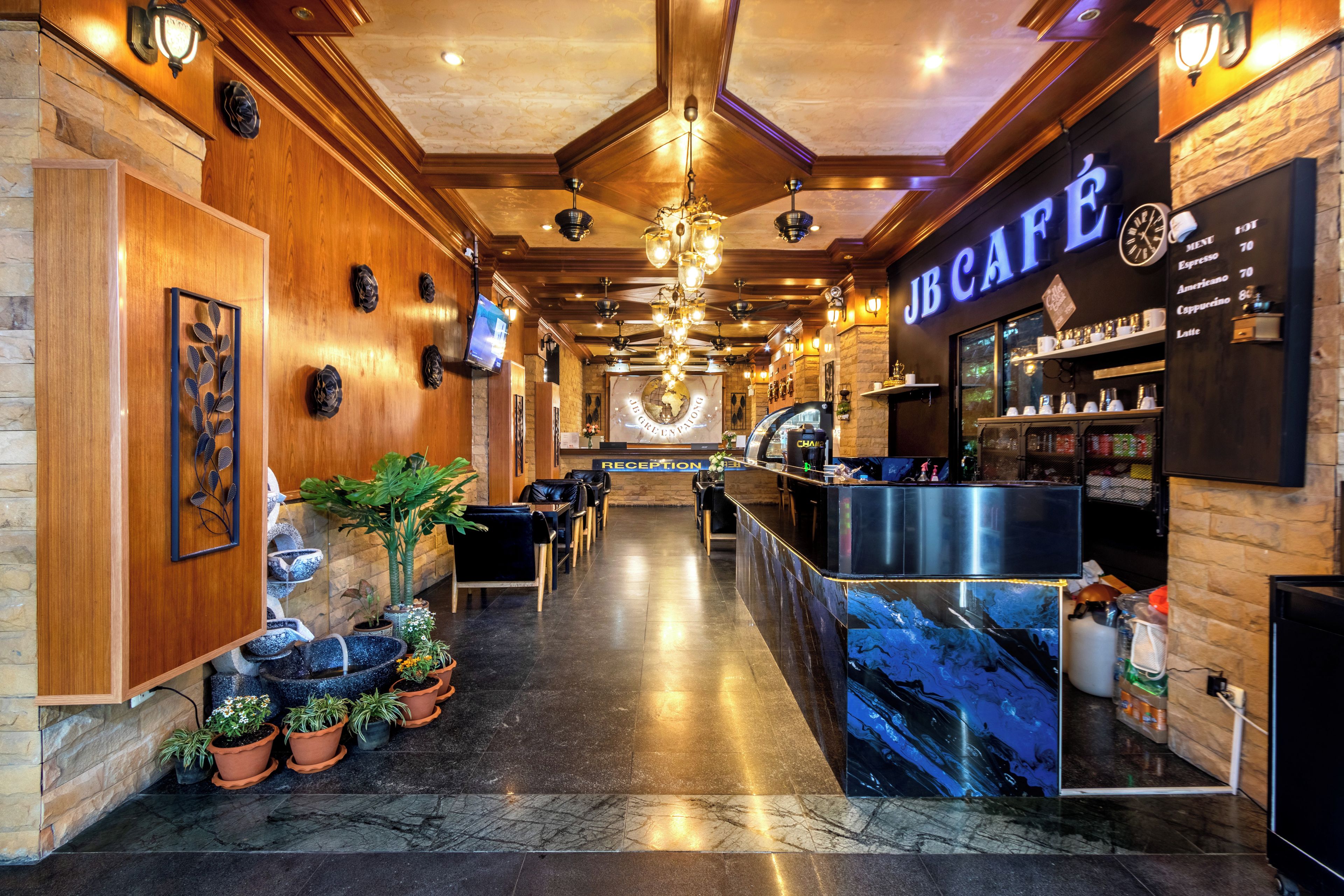 A reception area with a reception desk, seating, potted plants, and a clock on the wall.