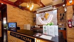 Una mesa de recepción de hotel con un letrero que dice "JB GREEN PATONG HOTEL" y una decoración con un globo terráqueo.