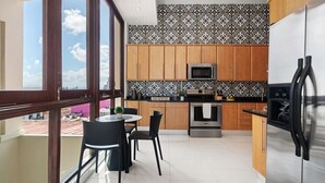 A modern kitchen with wooden cabinets, a stainless steel refrigerator, and a microwave.