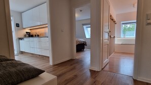 A modern apartment with a kitchen, a dining area, and a bedroom.