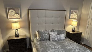 A bedroom with a large bed, two nightstands, and wall-mounted lamps. - Quiet and Cozy Home in the Heart of Southaven (Southaven)