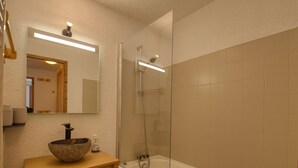 A bathroom with a stone sink, a mirror, a shower, and a bathtub. - Comfortable apt. for 6 on ski slopes in Morillon (Morillon 1100)