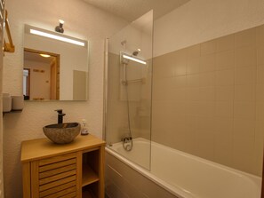 A bathroom with a stone sink, a mirror, a shower, and a bathtub. - Comfortable apt. for 6 on ski slopes in Morillon (Morillon 1100)