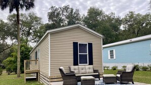 A mobile home with a deck, outdoor furniture, and a small porch. - Rainbow River Bungalow Q (Dunnellon)
