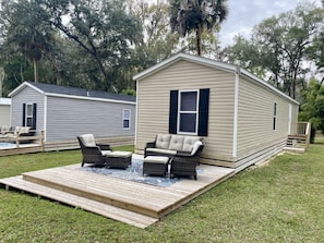 Une maison mobile dotée d’une terrasse, de mobilier d’extérieur et d’une petite piscine.