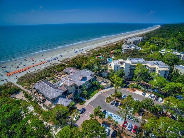 An aerial view of a coastal hotel with a beach view, parking area, and multiple buildings. - 2 BR Lagoon & Golf Views Walk to Ocean King 2 Twins Bikes & Beach Gear included (Hilton Head Island)