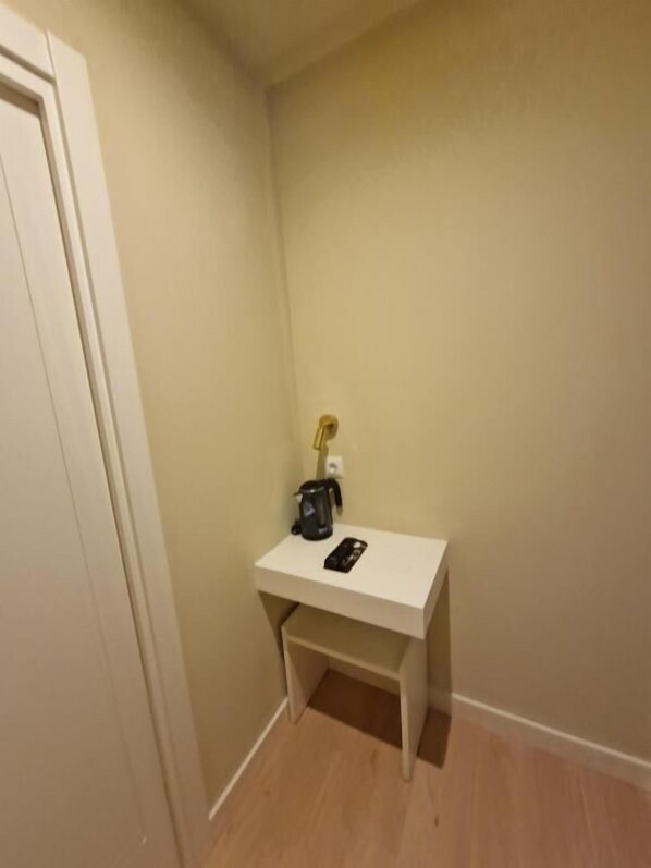 A small white desk with a black coffee maker and a smartphone. - Le Petit Palu Barco (Madrid)