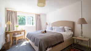 A bedroom with a bed, bedside lamps, a desk, and a window with curtains. - Arrow Lodge at Ragley Estate - sleeps 2 guests in 1 bedroom (Arrow)