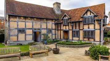 A traditional half-timbered building with a courtyard, benches, and a no entry sign.