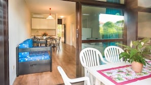 Un coin repas avec une table et des chaises, un canapé bleu et une cuisine en arrière-plan.