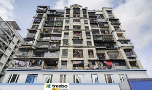 A multi-story building with numerous balconies, some with laundry hanging out to dry. - Hotel Amber Corp Inn (Mumbai)