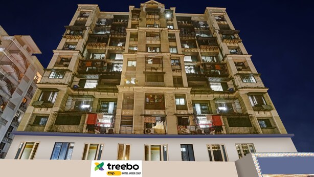Ein mehrstöckiges Hotel mit Balkonen und einem Schild mit der Aufschrift 'Treebo Trip Hotel Amber Corp'.