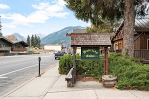 A sign for Bavarian Suites with a mountain backdrop.