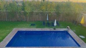 A rectangular swimming pool with a wooden deck surrounding it. - Villa Salah (Marrakech)