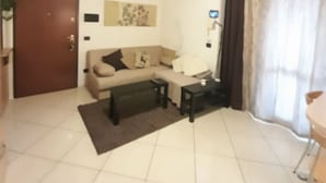 A living room with a sofa, coffee table, and a TV. - Iseolake 1-bed Apartment in Provaglio D'iseo (Provaglio d'Iseo)