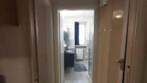 A narrow hallway with a tiled floor leading to a bathroom with a sink and a mirror. - Iseolake 1-bed Apartment in Provaglio D'iseo (Provaglio d'Iseo)