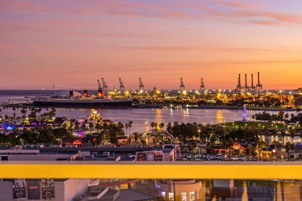 A waterfront industrial area with cranes and buildings at dusk.