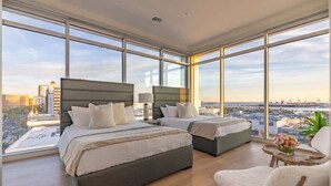 A high-rise hotel room with two beds, large windows, and a view of the cityscape. - @ Marbella Lane - Luxury Beachside 2BR (Long Beach)