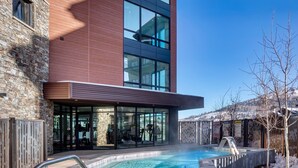 A modern building with a swimming pool, stone facade, and large windows. - Luxe Deer Valley Ski-In/Out. 50 ft to Lift. Bowling Alley, Hot Tub & Ski Valet (Park City)