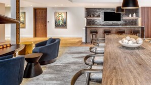 A modern kitchen with a black backsplash, a wooden ceiling, and a bar area with stools. - Luxe Deer Valley Ski-In/Out. 50 ft to Lift. Bowling Alley, Hot Tub & Ski Valet (Park City)