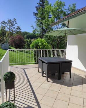Enjoy a tranquil outdoor space with a table and chairs surrounded by lush greenery.