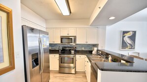 A modern kitchen with stainless steel appliances, a microwave, and a sink. - Newly remodeled oceanfront condo close to everything (Myrtle Beach)