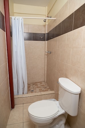 Eenvoudige tweepersoonskamer | Badkamer | Een douche, handdoeken, zeep, shampoo