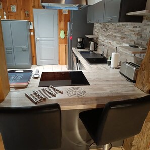 Efficient kitchen space with stove, sink, and toaster.
