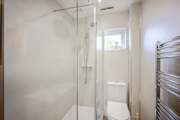 A modern bathroom with a glass-enclosed shower, a white toilet, and a chrome towel rack. - Carlisle - Apartment - Sleeps 5 - Pet-friendly (Carlisle)