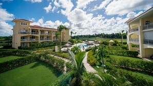 A resort with multiple buildings, a swimming pool, and well-maintained gardens. - Special offer for amazing apartment in Bavaro with the Wi-Fi, pool and security. (Bavaro)