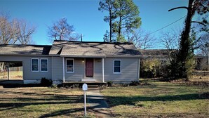 A single-story house with a front porch, a garage, and a small front yard.