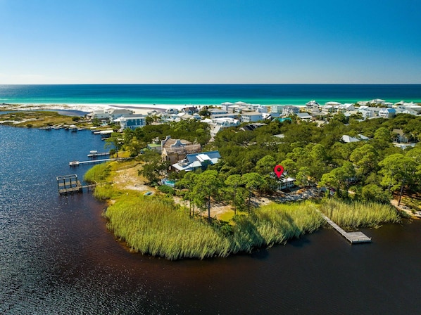 An aerial view of a coastal area with a marina, houses, and a red location marker. - Papa's Hideaway- secluded cottage in Grayton on the lake (Santa Rosa Beach)