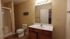 Une salle de bain avec des toilettes, un lavabo et un miroir.
