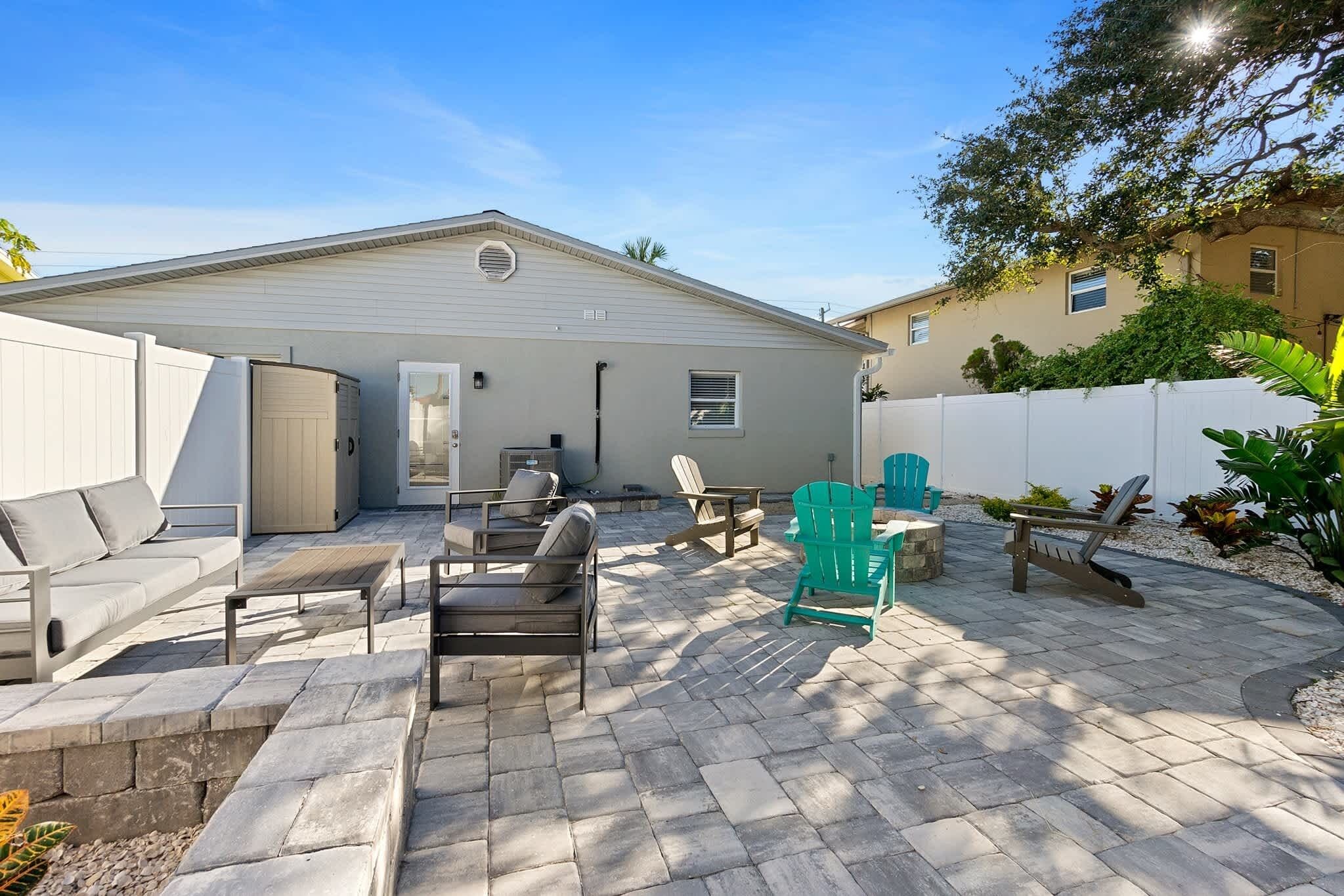 Un espace patio aménagé avec du mobilier d’extérieur, notamment un canapé, des fauteuils et une table.