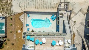 An aerial view of a rooftop pool area with a swimming pool, lounge chairs, and a wooden deck. - beach front home pool  many new upgrades (North Topsail Beach)