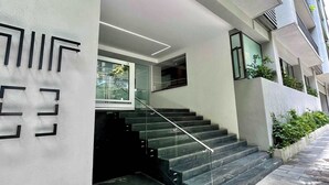 A modern building with a staircase leading to a glass door entrance. - Luxury stay in Condesa | Rooftop, Pool & Views (Ciudad de México)