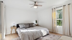 A bedroom with a bed, bedside tables, a ceiling fan, a window with curtains, and a rug. - Condo in Scottsdale (Scottsdale)