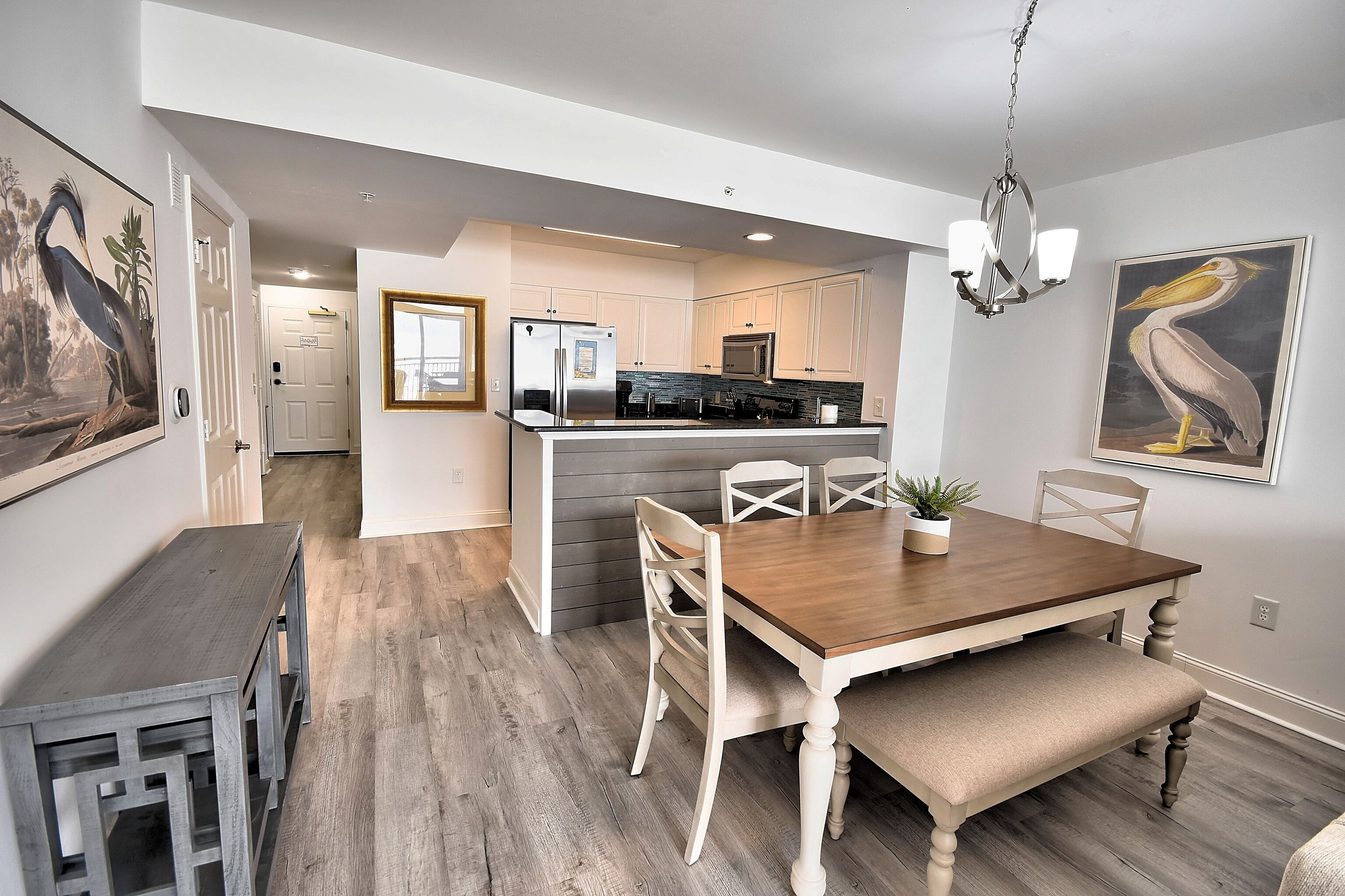 A modern kitchen with white cabinets, a stainless steel refrigerator, and a microwave.